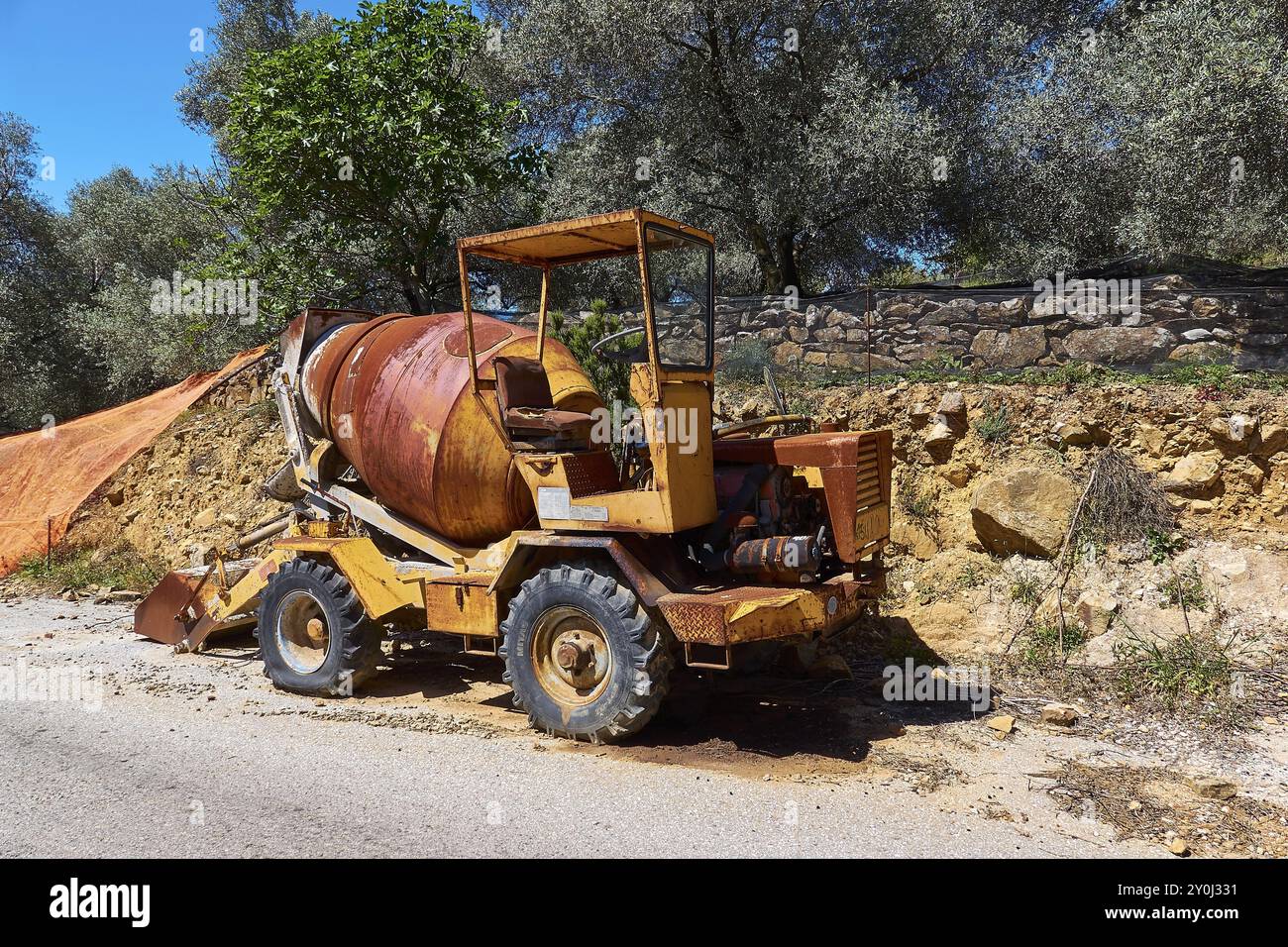 Rostgelbe Baumaschine mit verschlissenem Aussehen an der Straße in sonniger Umgebung, beschädigtes Fahrzeug, Kreta, griechische Inseln, Griechenland, Europa Stockfoto