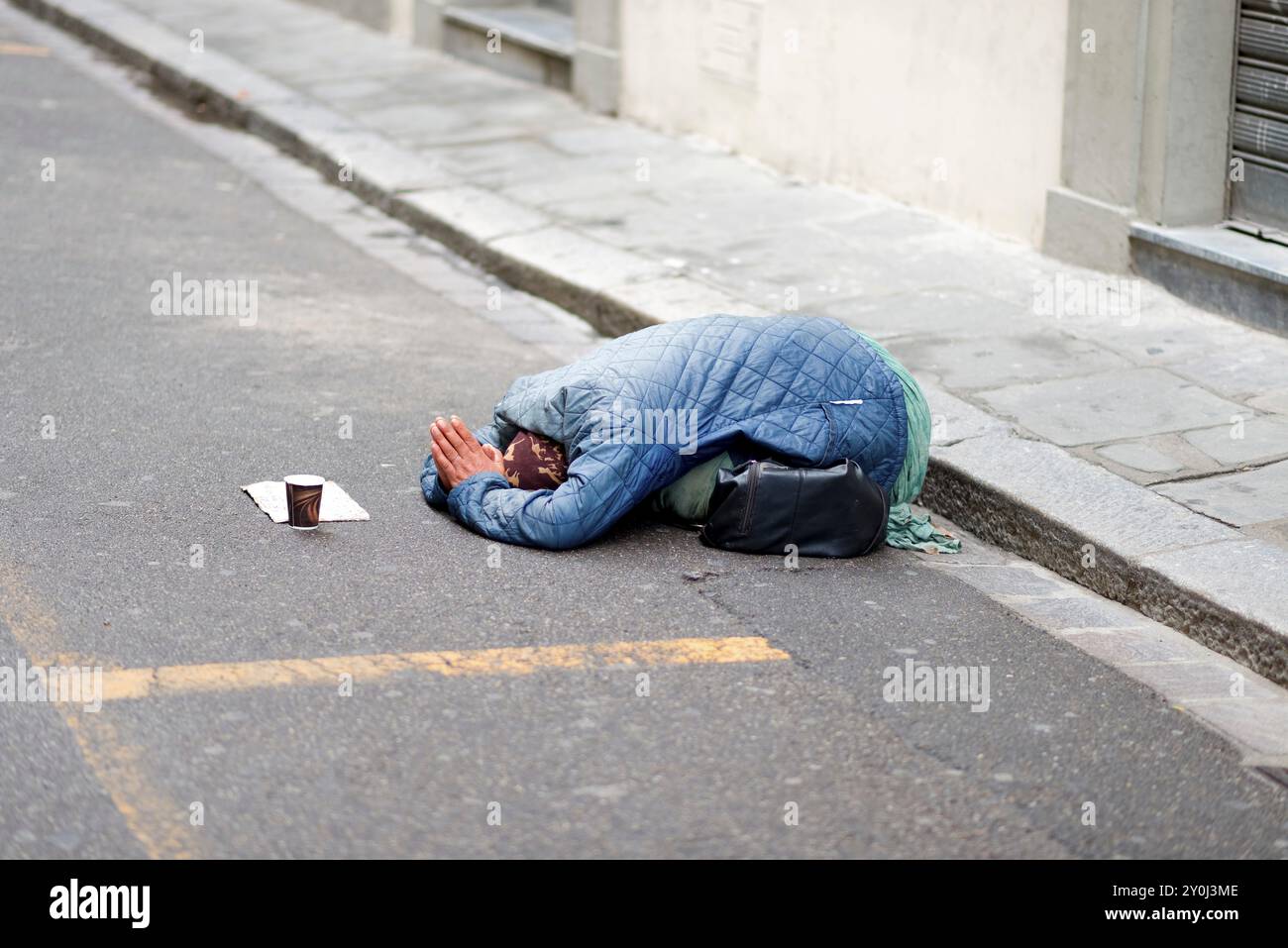 Unterwürfige Haltung einer Bettlerin Stockfoto