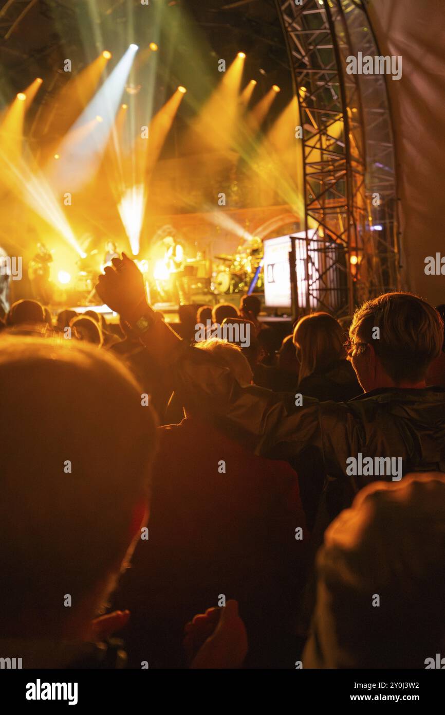 Die Massen genießen ein Konzert unter intensiver Beleuchtung, während Musiker auf der Bühne spielen, Klostersommer, Calw Hirsau, Schwarzwald, Deutschland, Europa Stockfoto