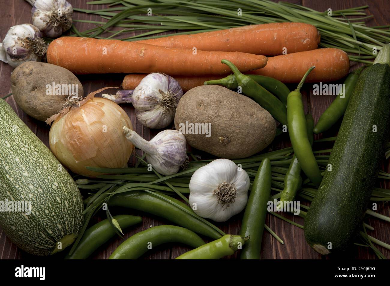 Eine Nahaufnahme von verschiedenen Gemüsesorten wie Knoblauch, Karotten, Schnittlauch, Zwiebeln, Kartoffeln, und Paprika Stockfoto