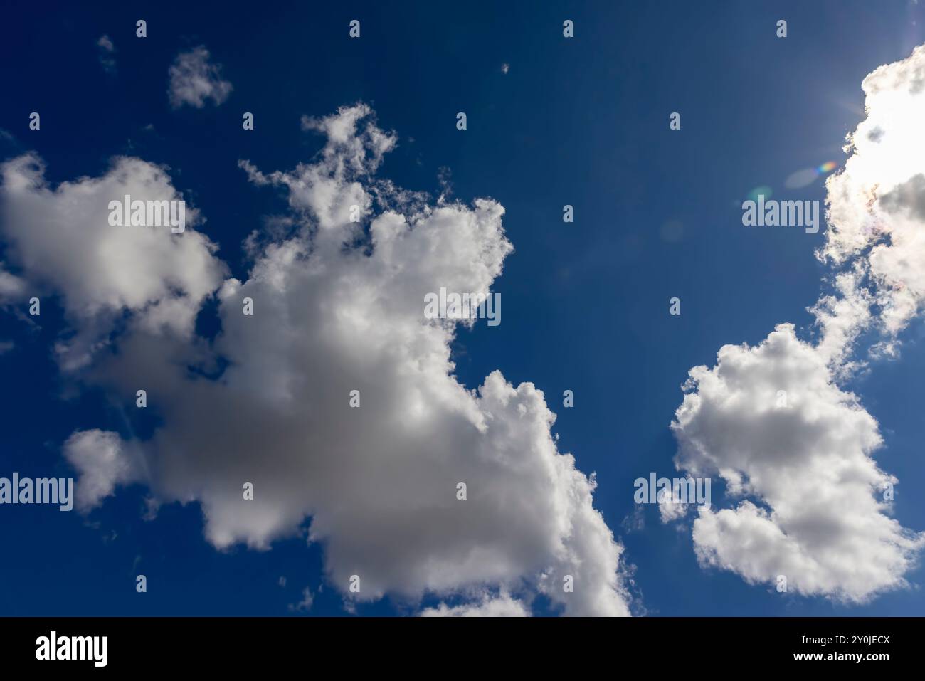 Von Sonnenlicht beleuchtet blauer Himmel mit Wolken und Sonne, schöner Himmel bei sonnigem hellem Wetter, helles Sonnenlicht scheint durch die Wolken Stockfoto Von Sonnenlicht beleuchtet blauer Himmel mit Wolken und Sonne, schöner Himmel bei sonnigem hellem Wetter, helles Sonnenlicht scheint durch die Wolken Stockfoto