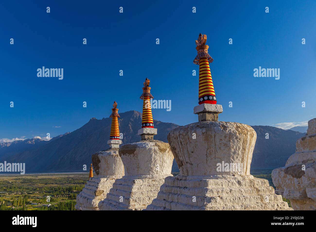 Viele weiße Stupas in einer Reihe auf einem Berg mit blauem Himmel im Hintergrund Stockfoto