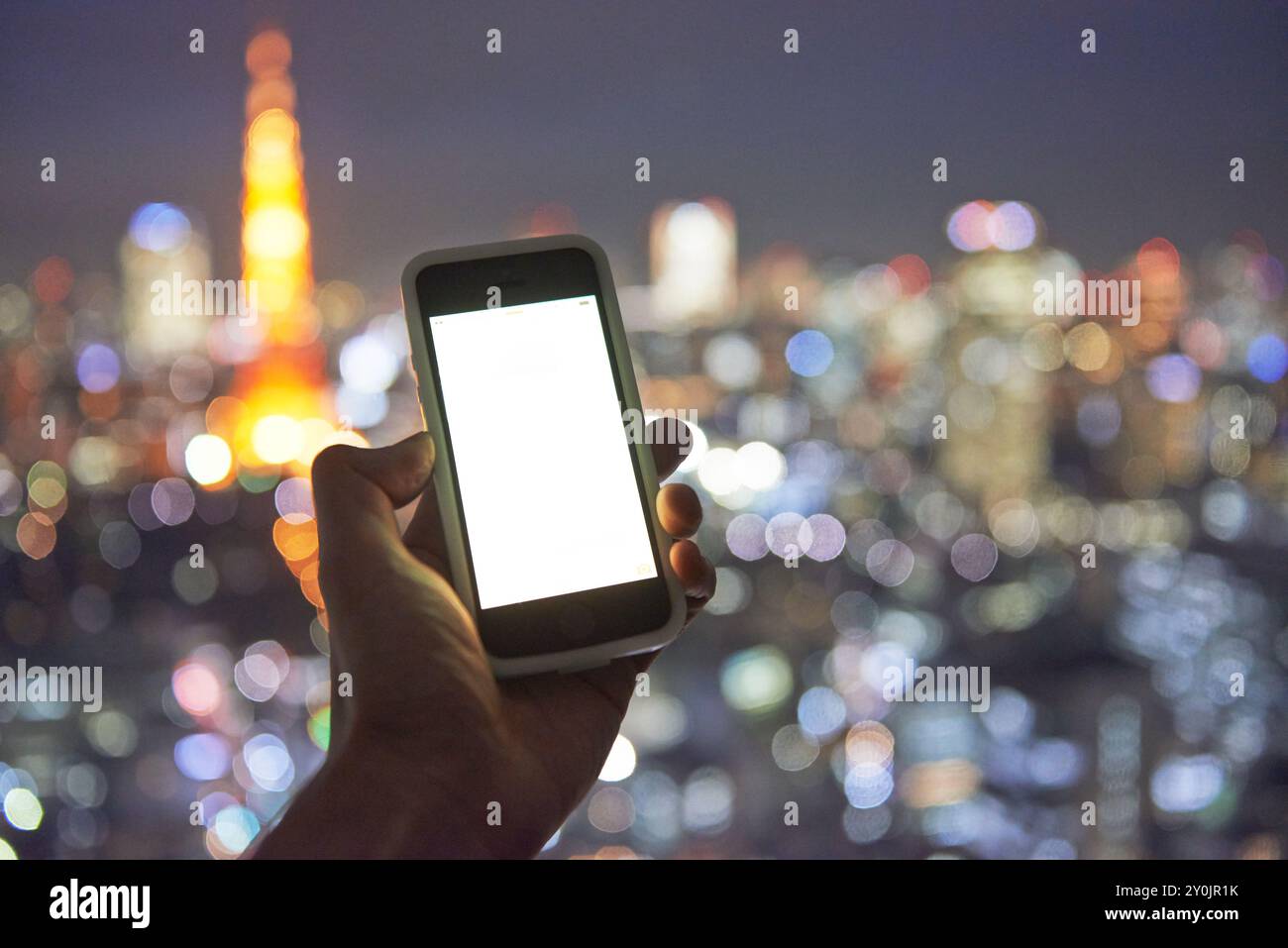 Nachtblick auf Tokio und ein Smartphone Stockfoto