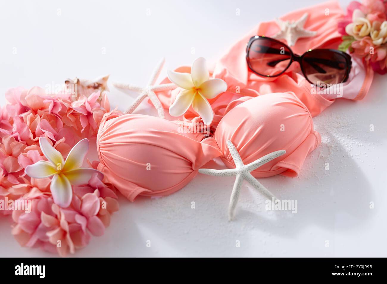 Sommerbilder in Rosa mit Badeanzügen und Blumenschmuck Stockfoto