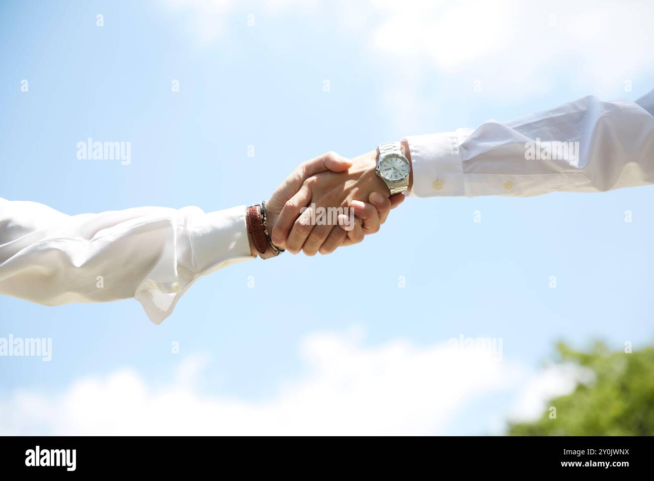 Die Hand eines Mannes, der unter dem blauen himmelweißen Hemd die Hände schüttelt Stockfoto