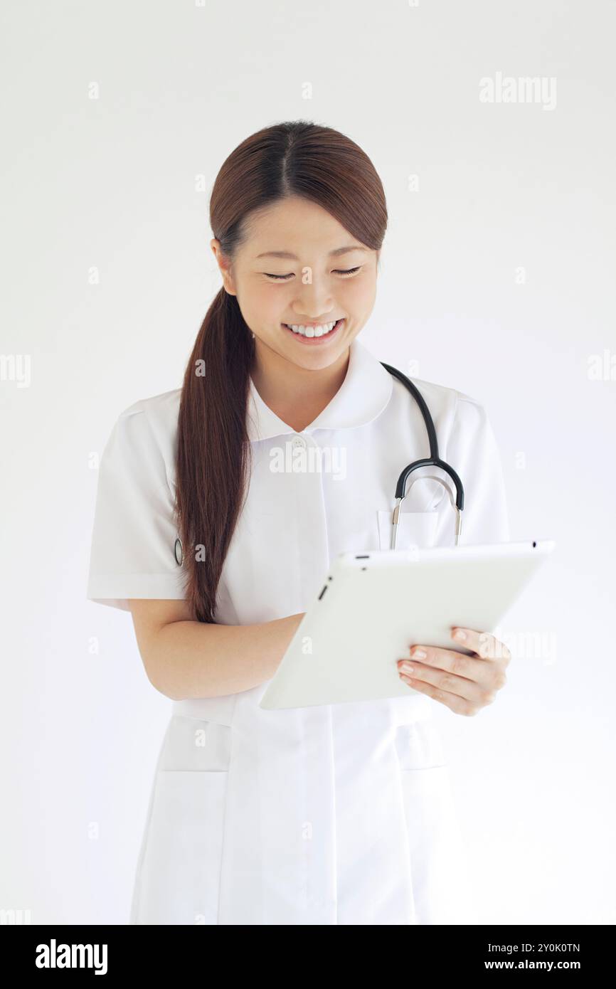 Schwester lächelt mit einem Tablet-PC Stockfoto