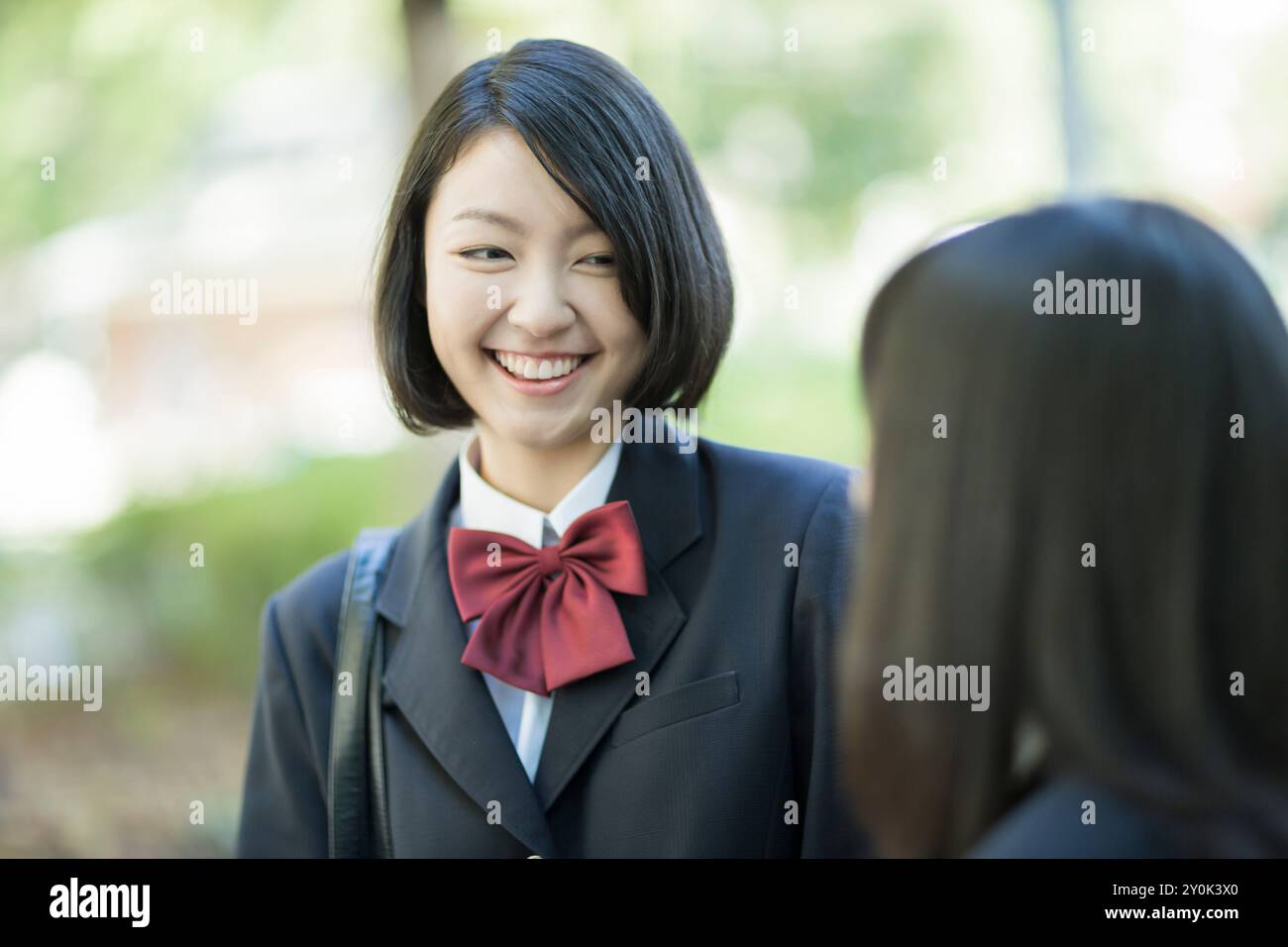 Highschool-Mädchen, die sich mit einem Lächeln unterhalten Stockfoto