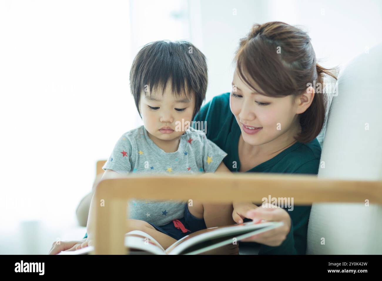 Eltern und Kinder lesen ein Bilderbuch Stockfoto