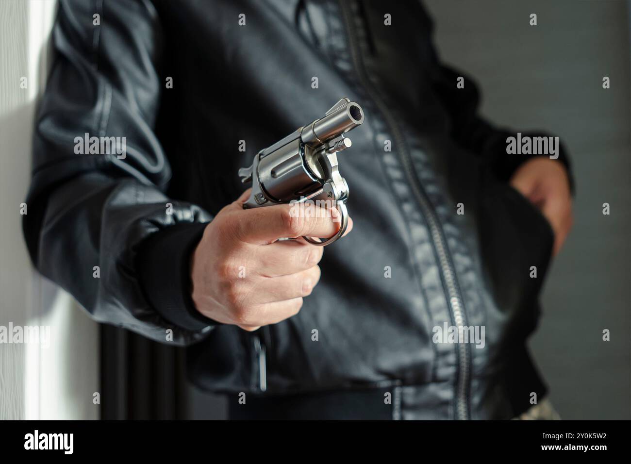Die perfekte Waffe für Ihre Selbstverteidigung. Ein Mann nimmt eine Waffe aus der Tasche, das Konzept der Notwehr oder Unterdrückung, Raub. Legalisation von fi Stockfoto