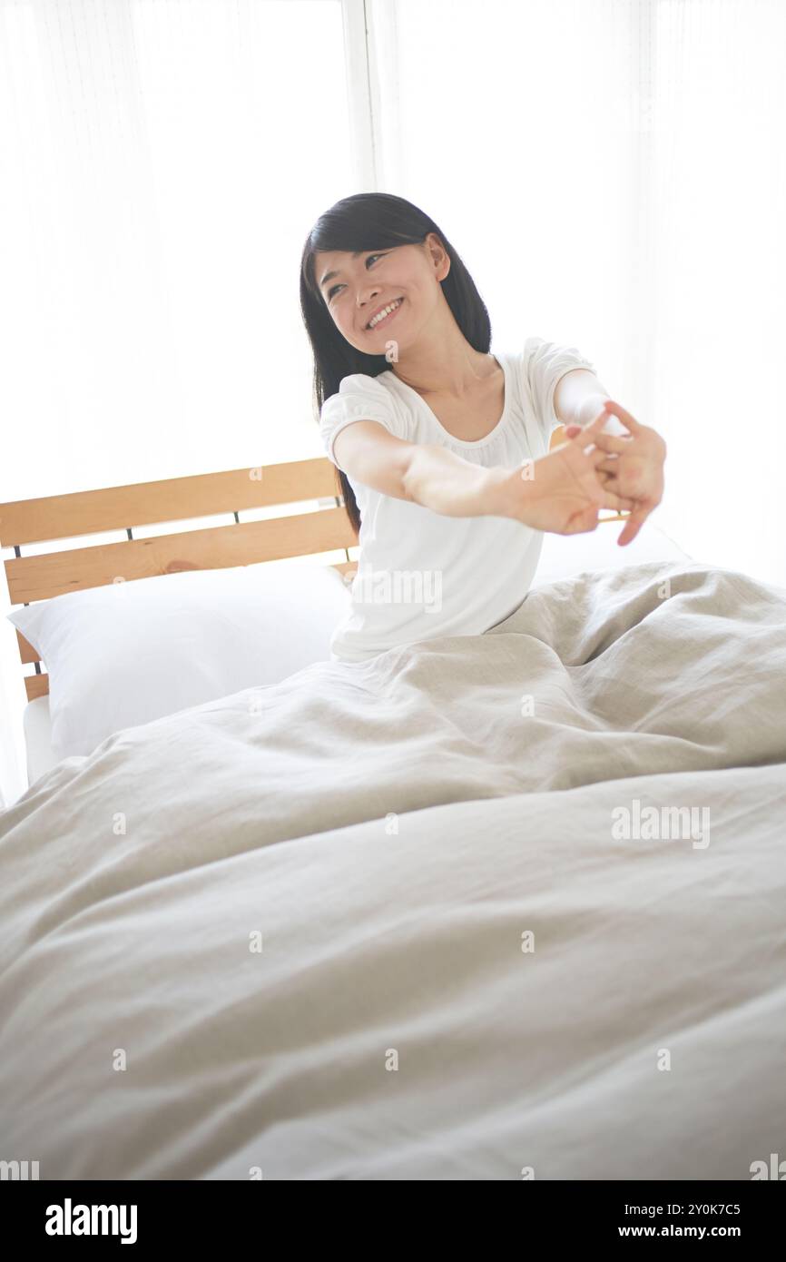 Frau auf dem Bett dehnen Stockfoto