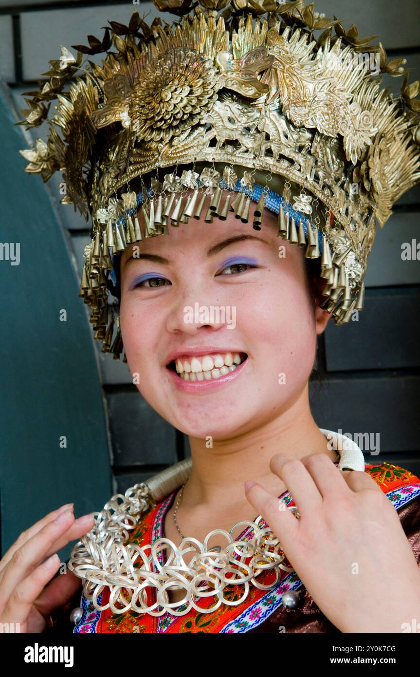 Porträt einer lächelnden Chinesin in einem Miao-Minderheitenkostüm. Foto in Nanjing, China. Stockfoto