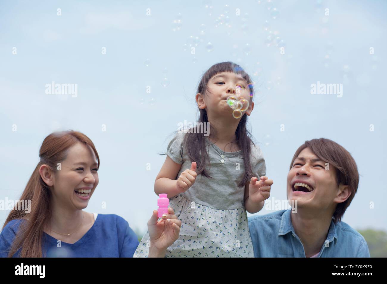 Japanische Familie spielt mit Seifenblasen Stockfoto