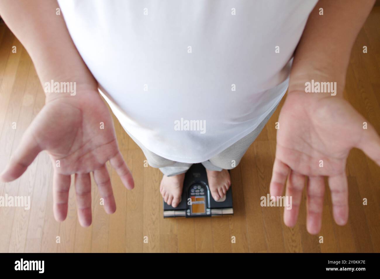 Gliedmaßen eines Mannes, der auf eine Waage kommt Stockfoto