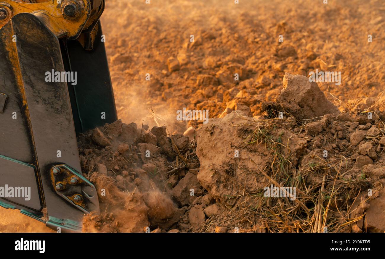 Metalleimer für Baggerlader, die Boden graben. Bagger arbeitet auf der Baustelle. Erdbewegungsmaschine. Aushubfahrzeug. Schwere Maschinen in Aktion. Stockfoto