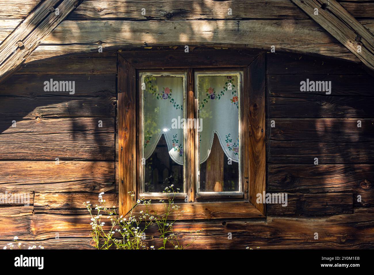 Fenster mit Vorhängen in einem alten Holzhaus Stockfoto