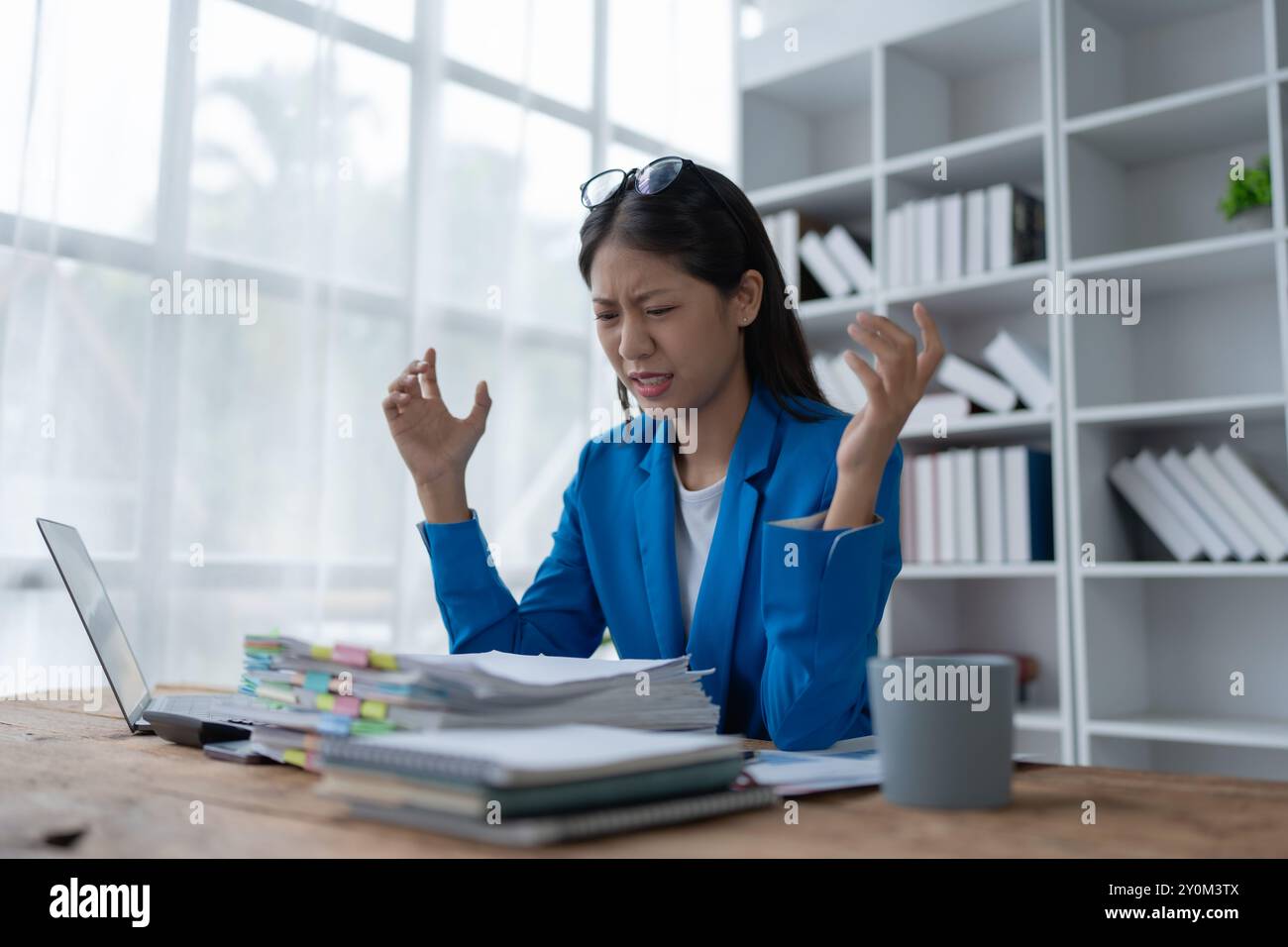 Geschäftsfrau plant eine Finanzprüfung, prüft Dokumente, während sie gegen das Burnout-Syndrom kämpft Stockfoto