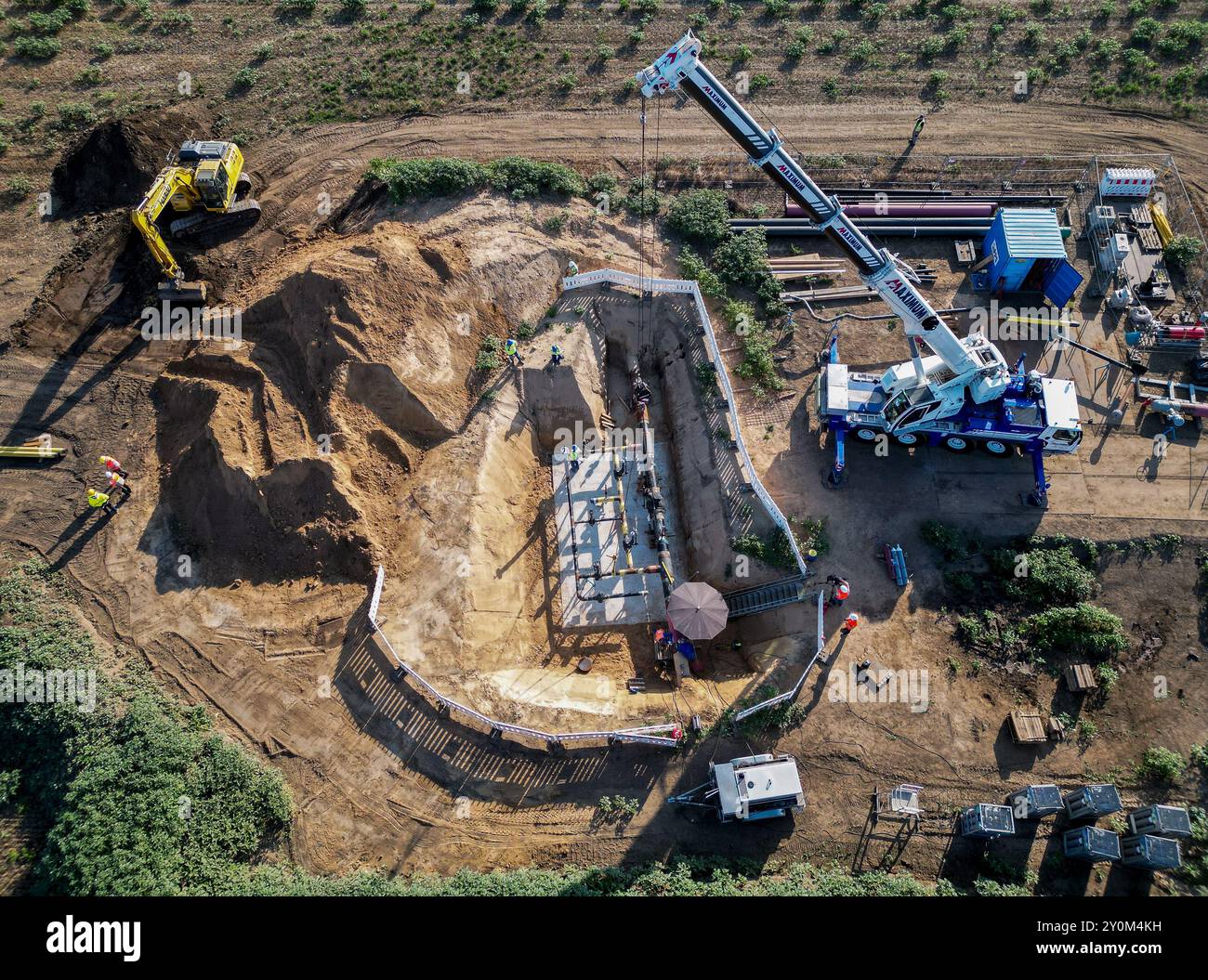 03. September 2024, Sachsen-Anhalt, Großkorbetha: Ein Kran wird eingesetzt, um eine Gruppe von Abzweigeinrichtungen für die künftige Wasserstoffpipeline vom Energiepark Bad Lauchstädt zur Raffinerie TotalEnergies in Mitteldeutschland im Chemiepark Leuna zu installieren. Im Rahmen eines realen Labors für die Energiewende wird hier eine bestehende 25 Kilometer lange Erdgaspipeline zu Wasserstoff umgebaut. Es wird auch der erste Abschnitt des mitteldeutschen Wasserstoffkernnetzes sein. Im Energiepark Bad Lauchstädt wird grüner Wasserstoff aus Windenergie und Elektrolyse erzeugt, unterirdisch gespeichert und gespeist Stockfoto