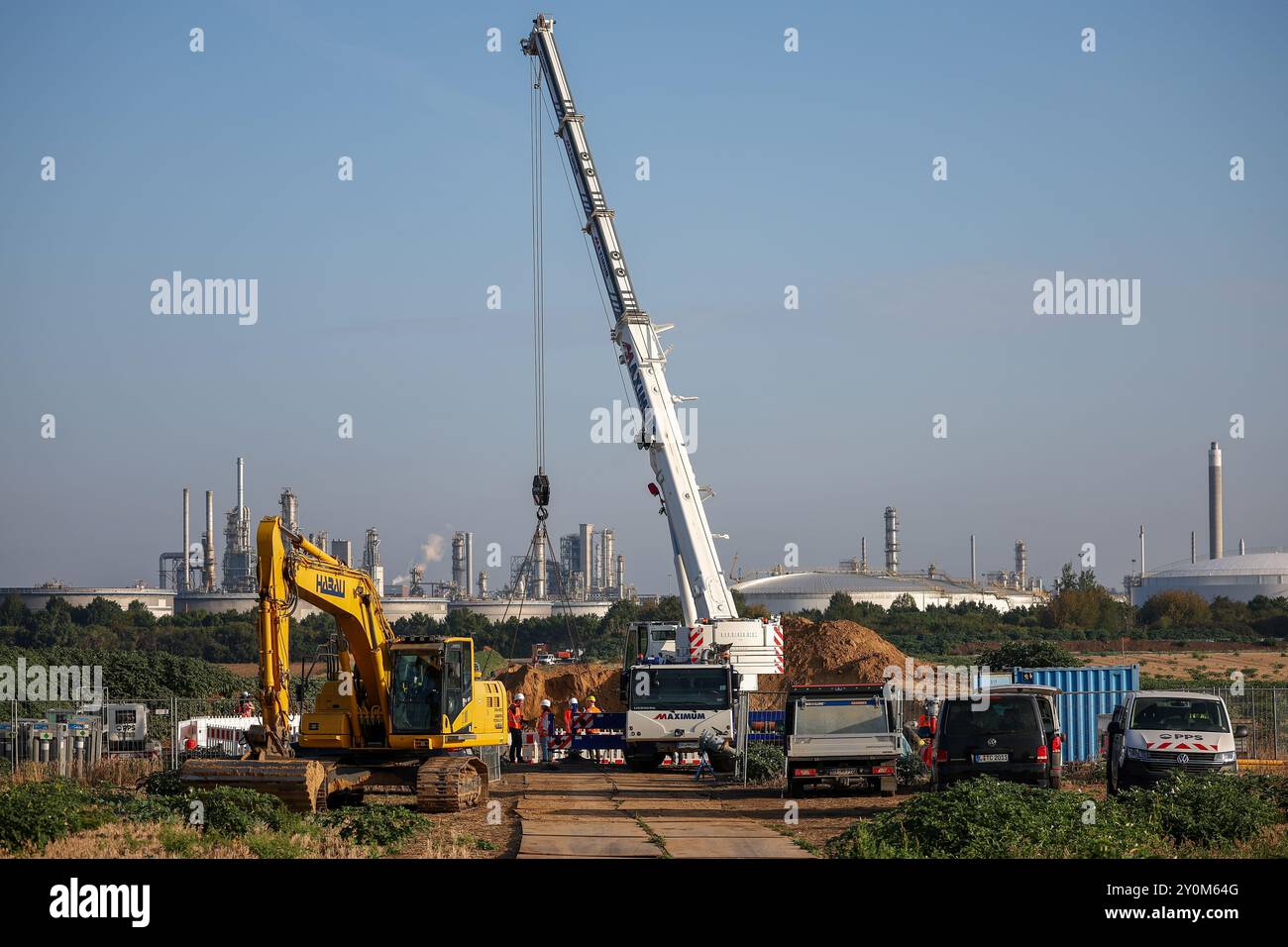 03. September 2024, Sachsen-Anhalt, Großkorbetha: Ein Kran wird eingesetzt, um eine Gruppe von Abzweigeinrichtungen für die künftige Wasserstoffpipeline vom Energiepark Bad Lauchstädt zur Raffinerie TotalEnergies in Mitteldeutschland im Chemiepark Leuna zu installieren. Im Rahmen eines realen Labors für die Energiewende wird hier eine bestehende 25 Kilometer lange Erdgaspipeline zu Wasserstoff umgebaut. Es wird auch der erste Abschnitt des mitteldeutschen Wasserstoffkernnetzes sein. Im Energiepark Bad Lauchstädt soll zukünftig grüner Wasserstoff aus Windenergie und Elektrolyse, gespeichert unter Wasser, erzeugt werden Stockfoto