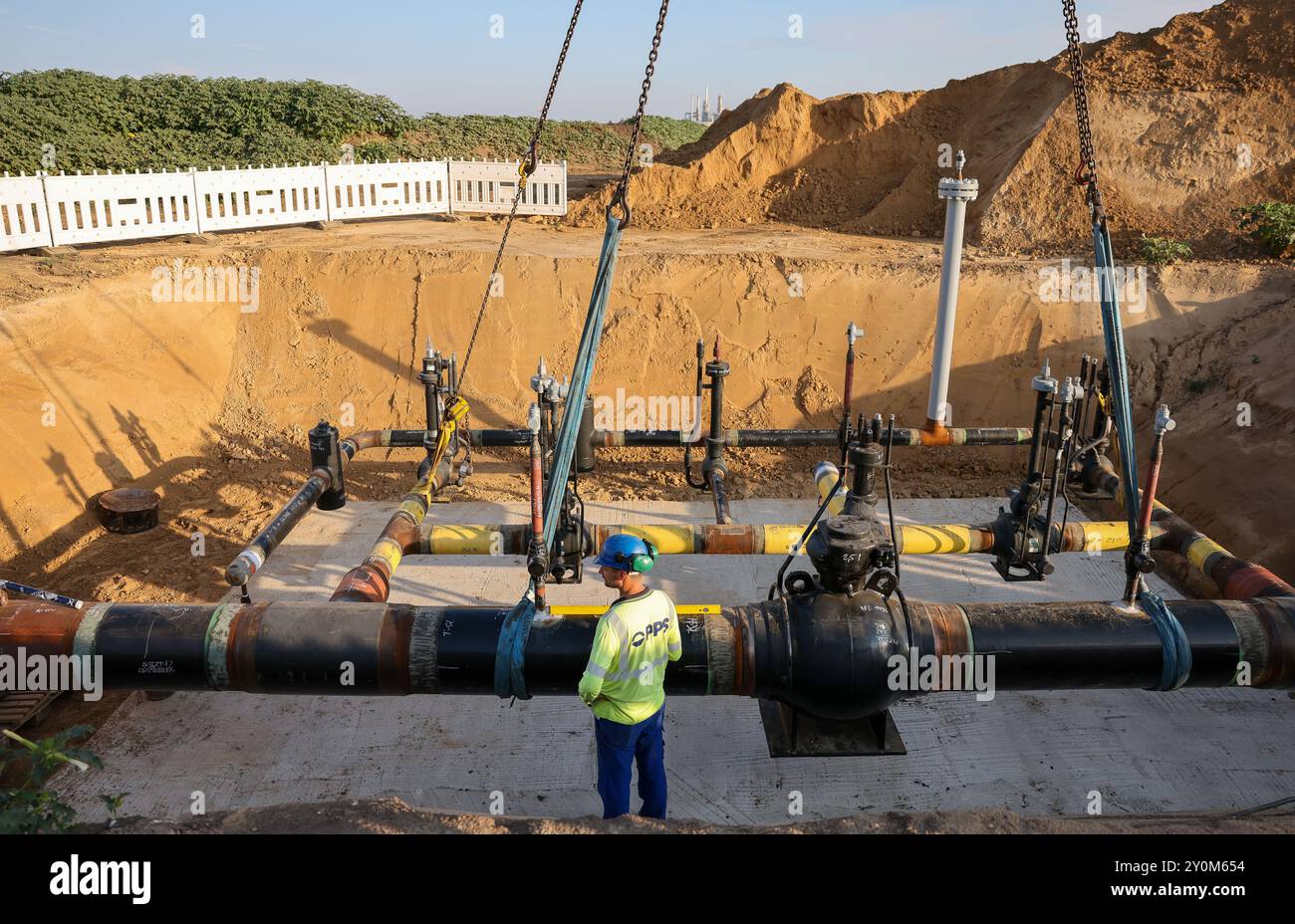 03. September 2024, Sachsen-Anhalt, Großkorbetha: Ein Zweigverbund für die künftige Wasserstoffpipeline vom Energiepark Bad Lauchstädt zur Raffinerie TotalEnergies in Mitteldeutschland am Chemiepark Leuna wird mit einer Schweißnaht installiert. Im Rahmen eines realen Labors für die Energiewende wird hier eine bestehende 25 Kilometer lange Erdgaspipeline zu Wasserstoff umgebaut. Es wird auch der erste Abschnitt des mitteldeutschen Wasserstoffkernnetzes sein. Im Energiepark Bad Lauchstädt soll zukünftig grüner Wasserstoff aus Windenergie und Elektrolyse, die unterirdisch gespeichert werden, erzeugt werden Stockfoto