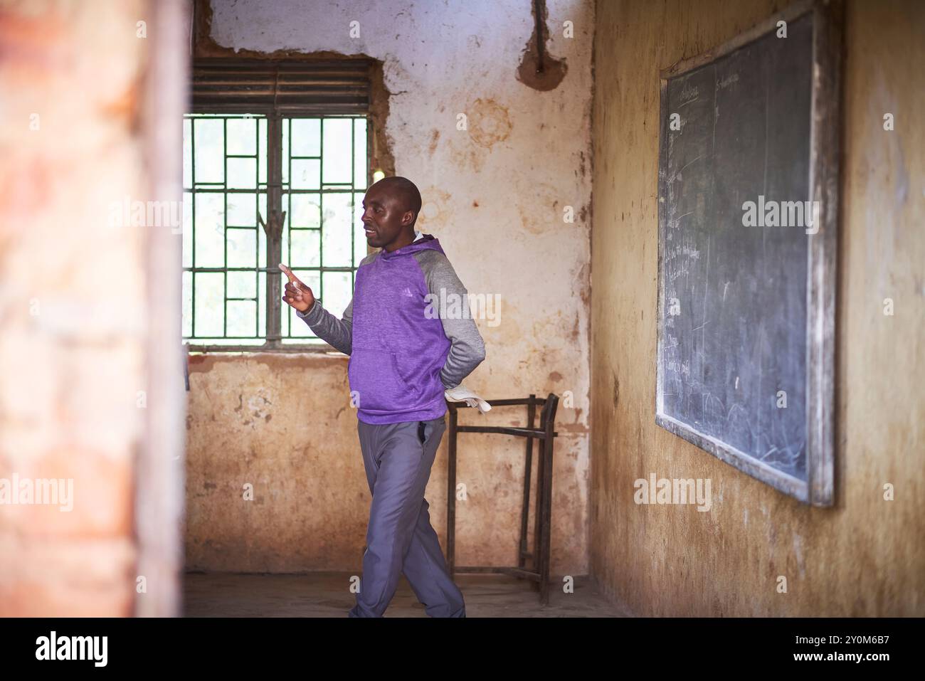 Reale Erziehung in einer ländlichen ugandischen Privatschule nahe der Grenze zur Demokratischen Republik Kongo in Ostafrika, mit dem Lehrerunterricht und den Kindern starren Stockfoto