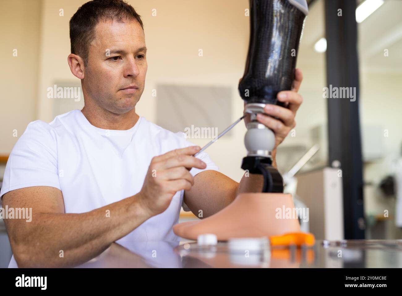 Techniker, der die Beinprothese im Labor verstellt, mit Fokus auf die präzise Ausrichtung Stockfoto