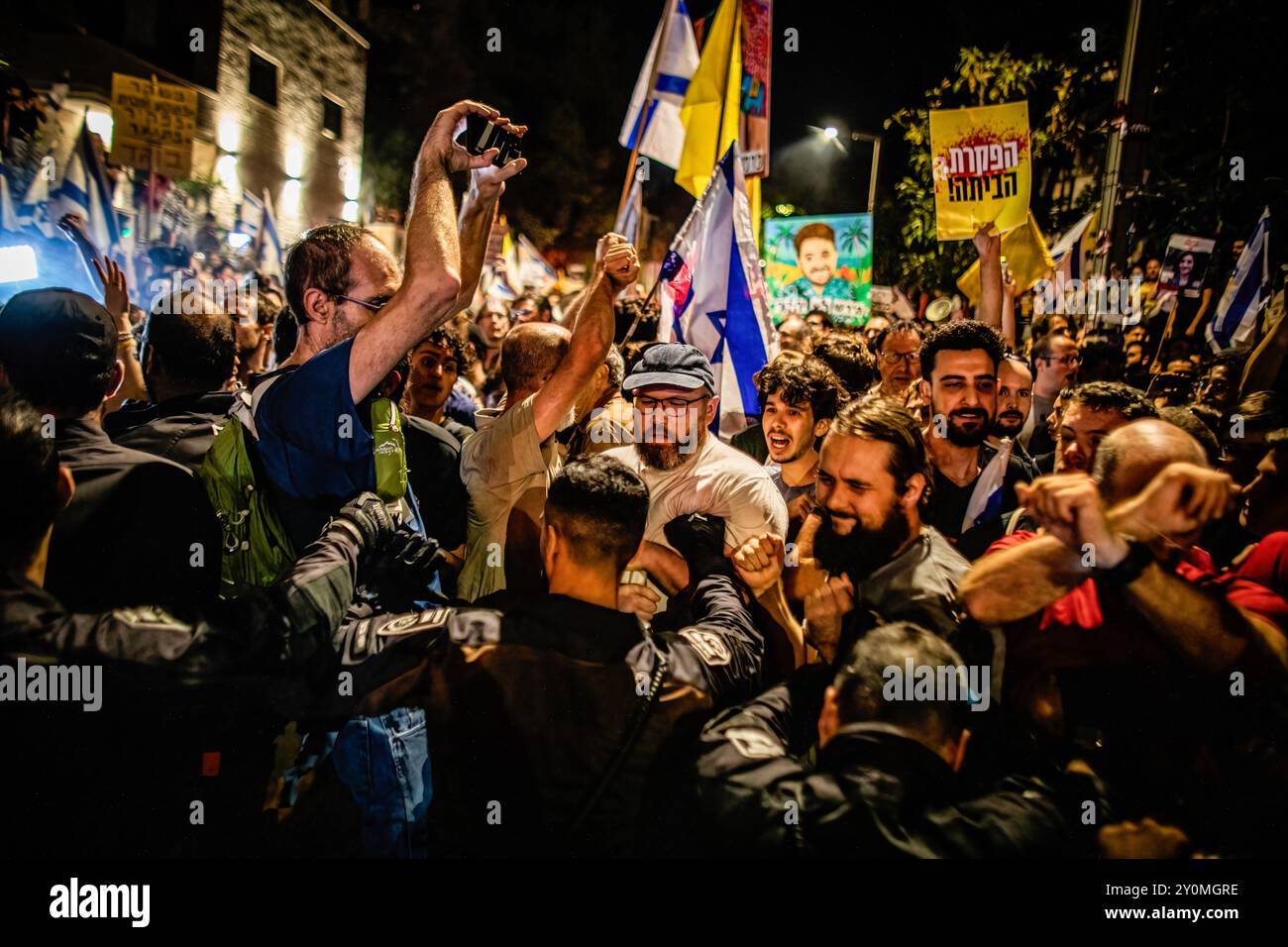 Demonstranten werden von israelischen Polizisten während einer Demonstration nach der Beerdigung von Hersh Goldberg Polin zurückgeschoben. Zehntausende Menschen haben sich für einen zweiten Tag in Israel versammelt, nachdem die Leichen von Karmel Gat, Eden Yerushalmi, Hersh Goldberg-Polin, Alexander Lobanov, Almog Sarusi und Meister Sgt Ori Danino aus Gaza gerettet wurden. Demonstranten rufen Premierminister Benjamin Netanjahu und seine Regierung auf, eine Einigung zu erzielen, um die Freilassung der verbleibenden Geiseln zu erreichen, die von der Hamas während der Angriffe vom 7. Oktober ergriffen wurden. Stockfoto