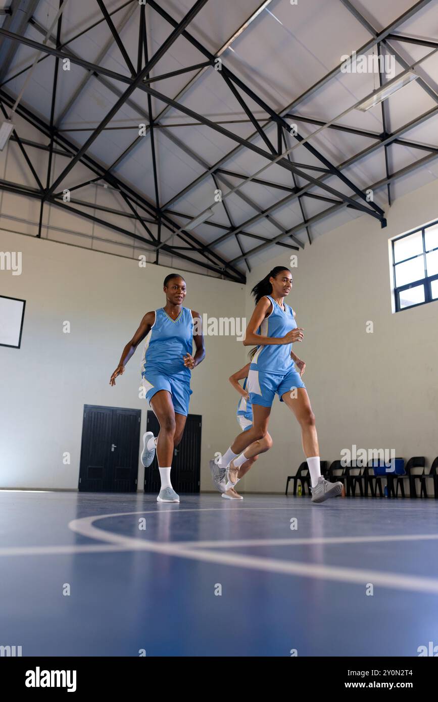 Basketball spielen, Athletinnen laufen während des Trainings auf dem Hallenplatz, Kopierraum Stockfoto