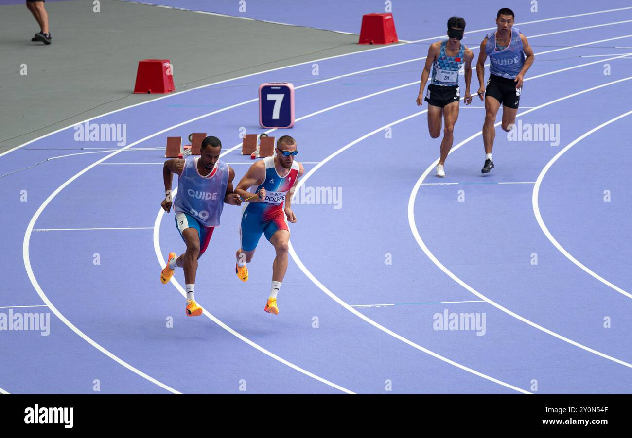 Der blinde französische Paralympic-Athlet Timothée Adolphe mit seinem Reiseleiter lief für die 400-m-Strecke im Stade de France für die Paralympischen Spiele 2024 in Paris. Stockfoto