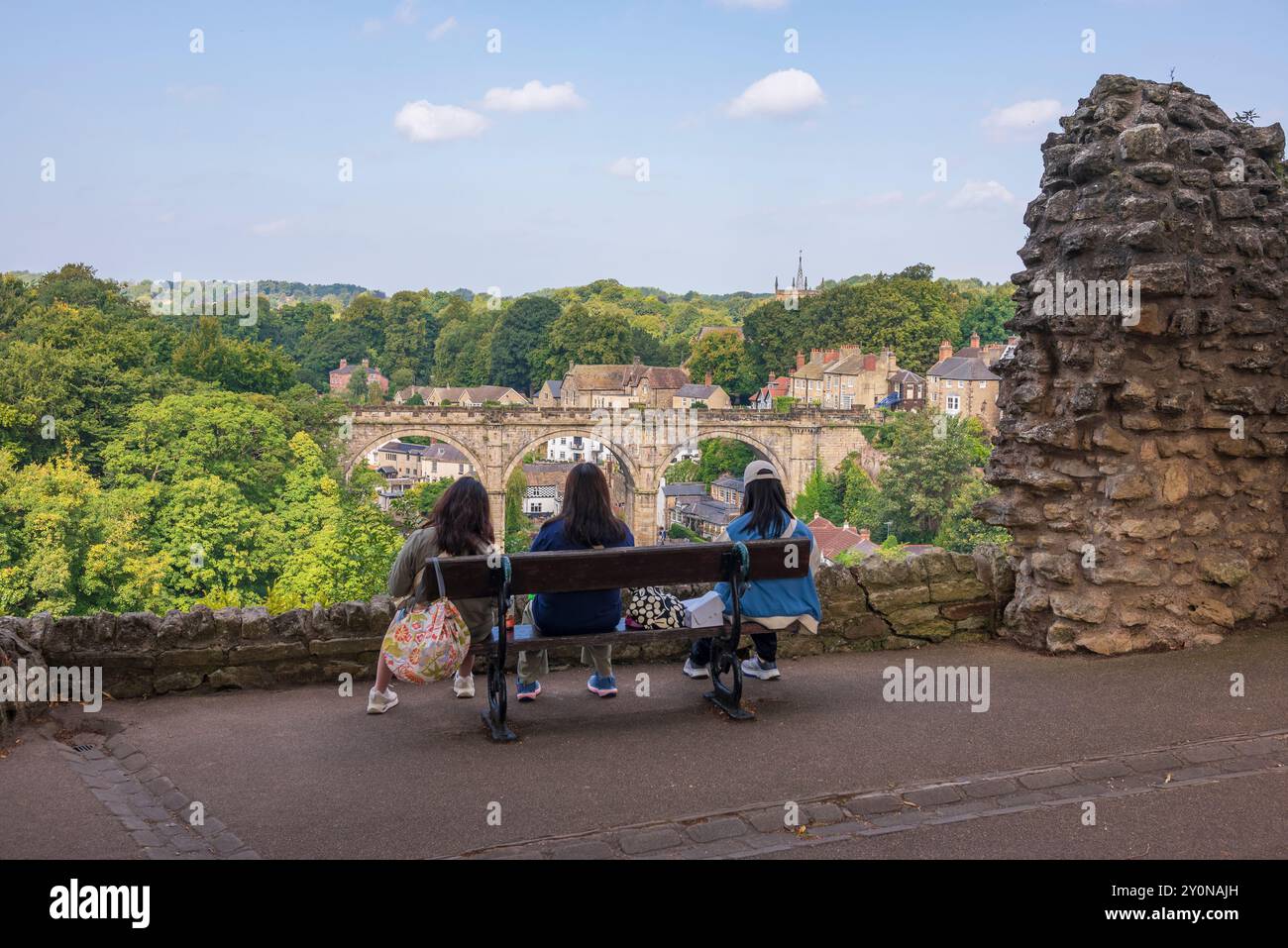 Drei Frauen sitzen auf einer Bank und blicken von Knaresborough Castle, North Yorkshire Stockfoto