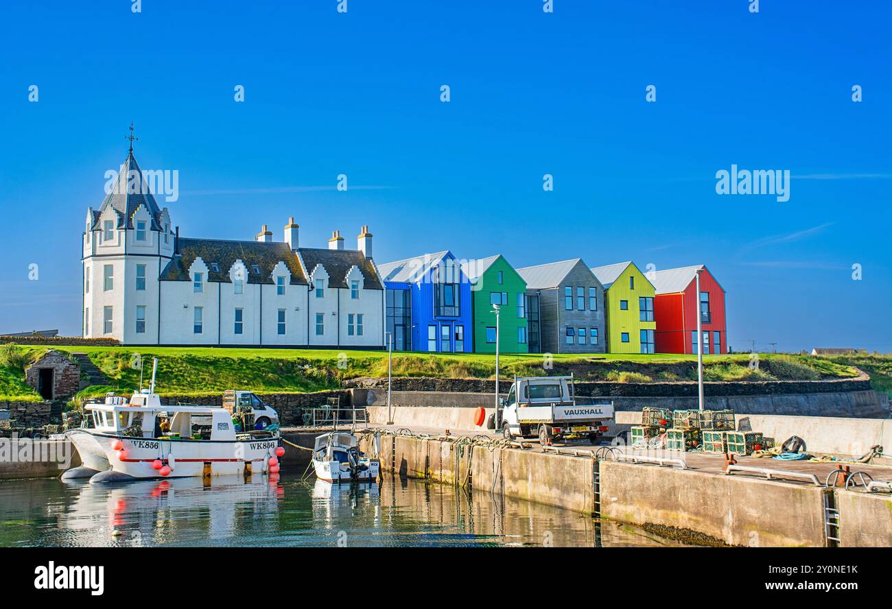John o' Groats House Hotel Caithness weißes Gebäude mit achteckigem Turm und farbenfrohen Erweiterungen mit Blick auf den Hafen im Sommer Stockfoto