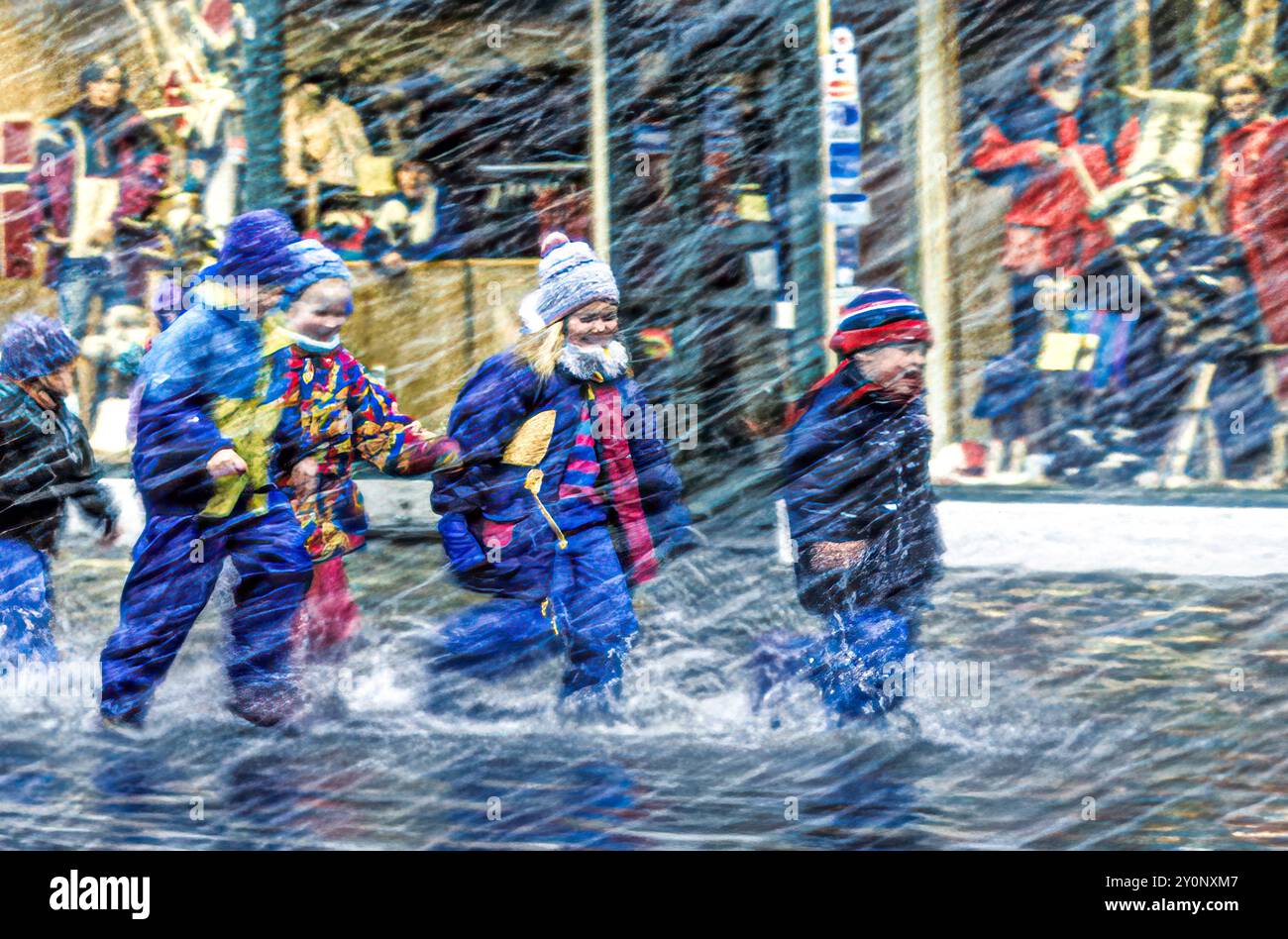 Kinder genießen extreme Wetterbedingungen in Bergen, Norwegen, mit überfluteten Straßen und starken Regenfällen. Stockfoto