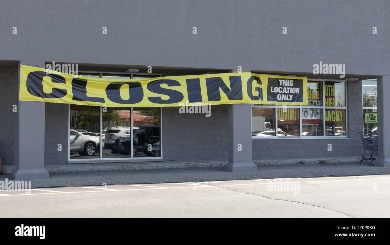 Schilder zum Schließen des Stores und zum Auslaufen des Geschäfts werden in einem bald geschlossenen Store angezeigt. Stockfoto