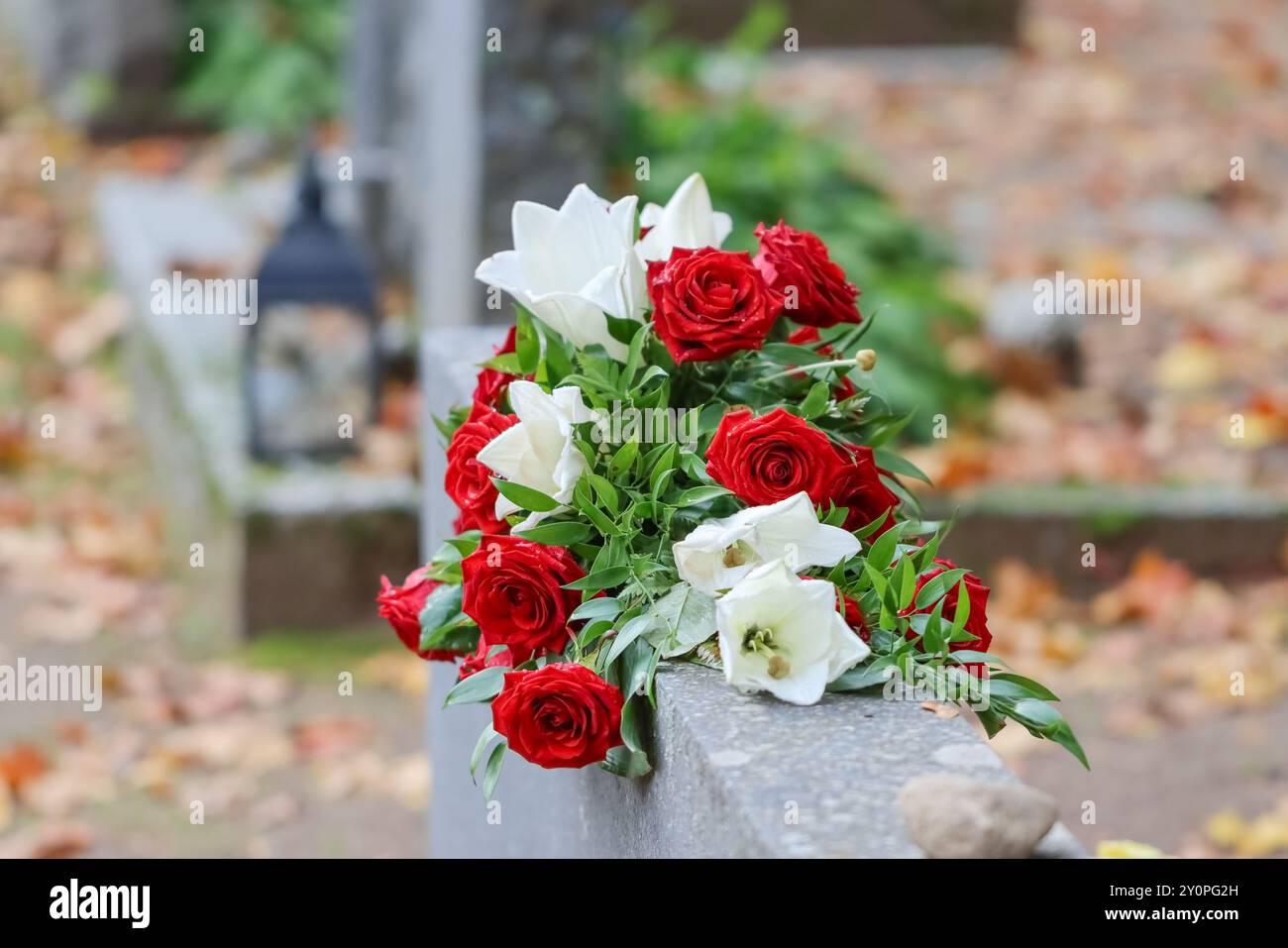 Schöne Grabblumen auf dem Friedhof. Verwandte wollen sich mit Blumen an die Verstorbenen erinnern. Ein wunderschöner Blumenstrauß tröstet trauernde Verwandte. Stockfoto