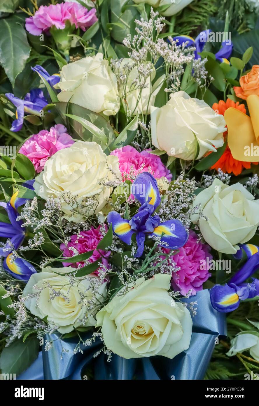 Schöne Grabblumen auf dem Friedhof. Verwandte wollen sich mit Blumen an die Verstorbenen erinnern. Ein wunderschöner Blumenstrauß tröstet trauernde Verwandte. Stockfoto