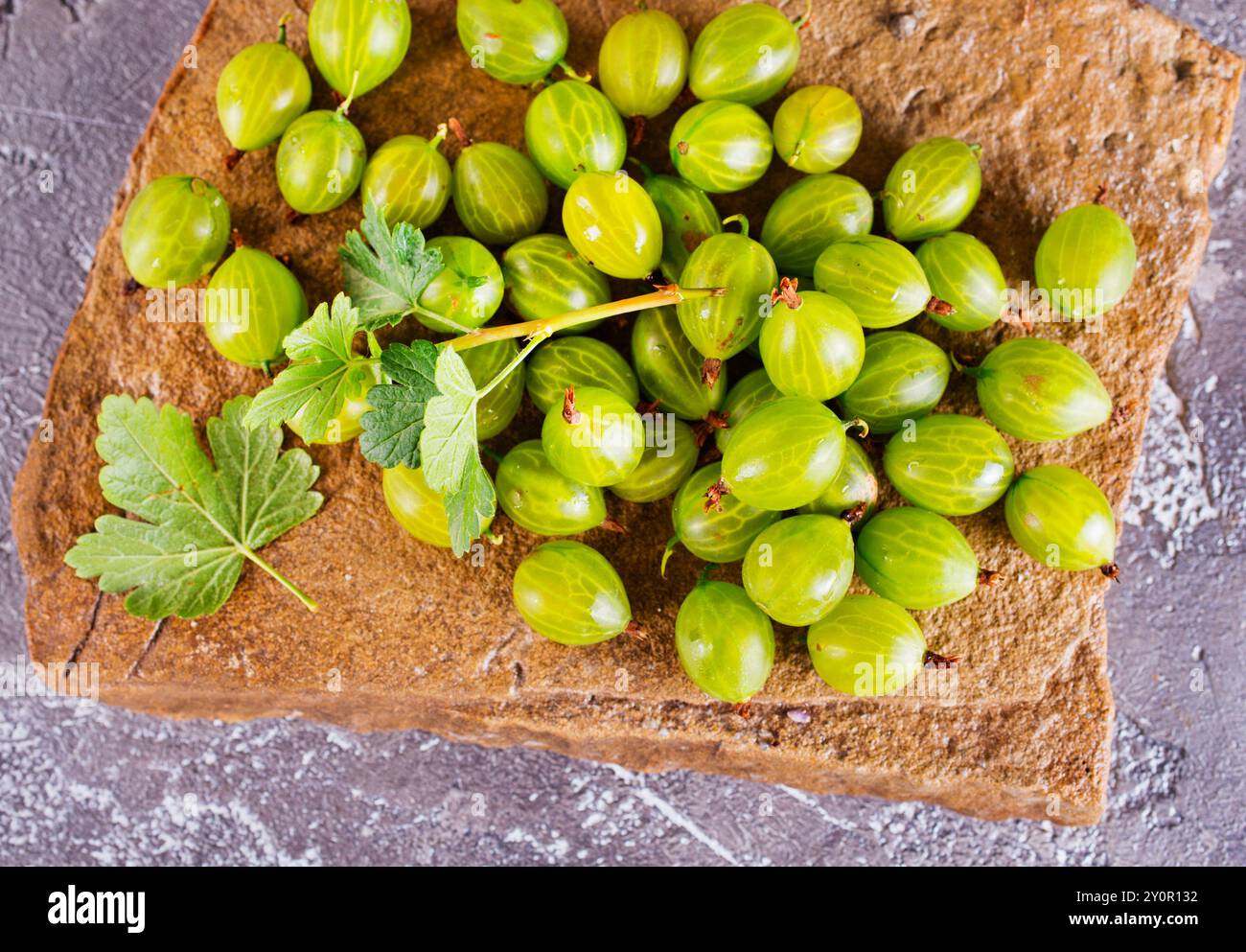 Frische Bio-Stachelbeeren in einer Holzschale auf einem Tisch Stockfoto