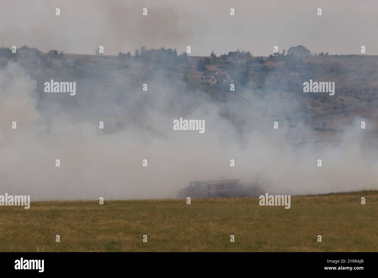 Waldbrände stellen vor allem in Grünland große Gefahren für den ländlichen Raum dar. Grasfeuer wurde durch Heurennen über ein Feld im Cascade County, MT, ausgelöst. Stockfoto