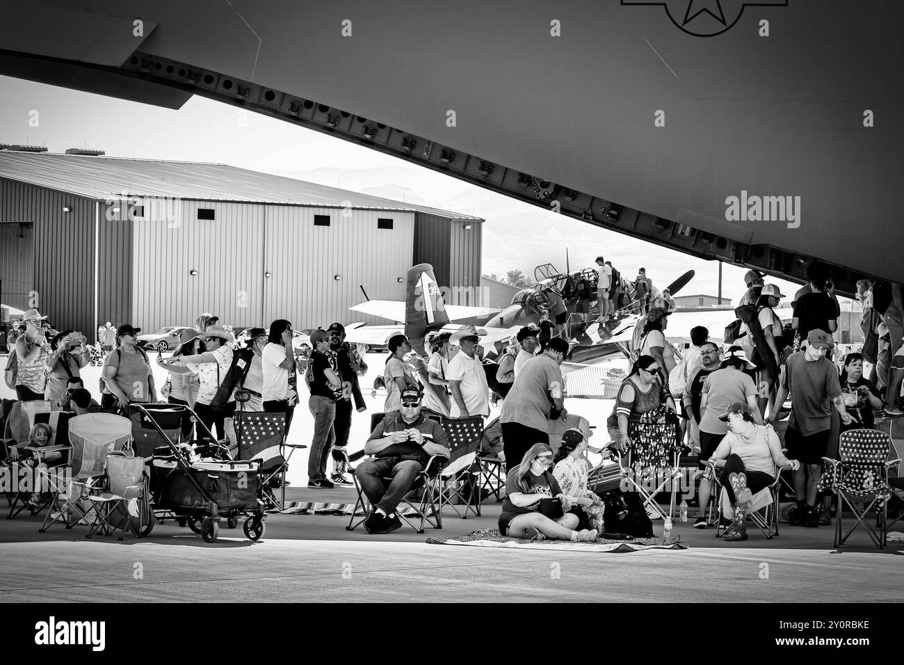 Airshow-Fans erhalten bei der Legacy of Liberty Airshow 2024 auf der Holloman Air Force Base in der Nähe von Alamogordo, New Mexico, etwas Schatten unter einem C-17 Globemaster. Stockfoto