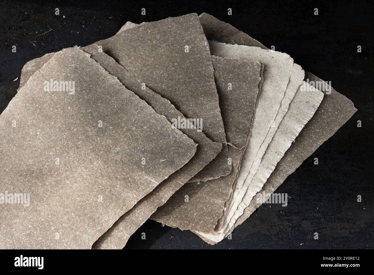 Nahaufnahme von handgefertigten Leinpapierblättern vor dunklem Hintergrund. Stockfoto