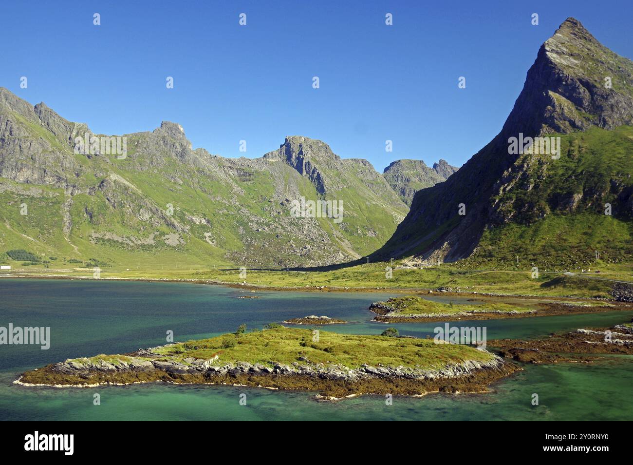 Natürliche Landschaft mit grünen Inseln und umliegenden Bergen unter blauem Himmel, Fredvang, Lofoten Wall, Lofoten, Nordland, Norwegen, Europa Stockfoto