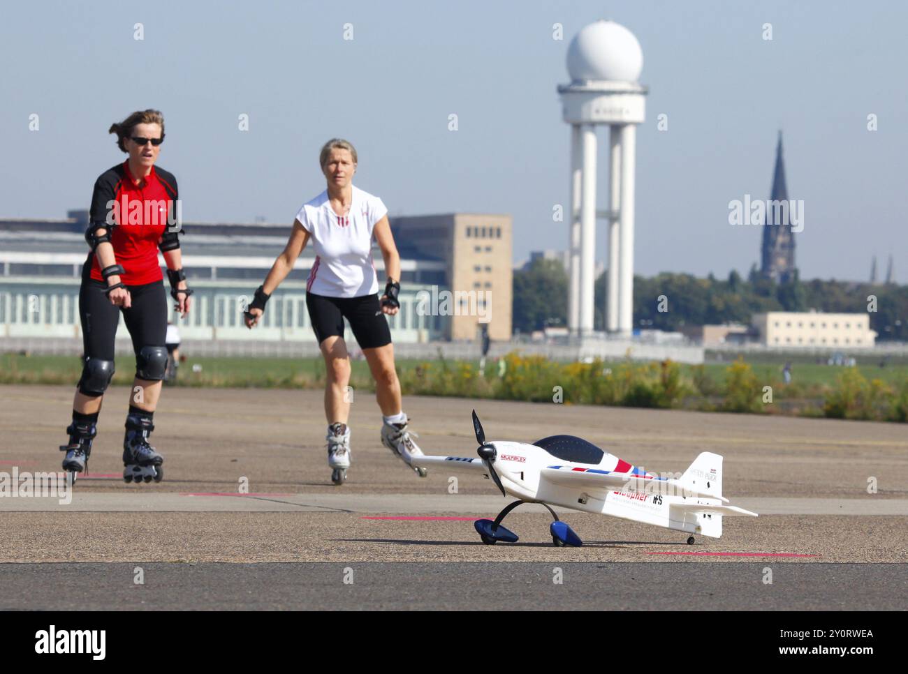 Berlin, 12.10.09 2010, Inlinerblader fahren an einem Modellflugzeug vorbei auf der Landebahn des ehemaligen Flughafens Tempelhof, heute Tempelhofer Feld, Berlin, Germa Stockfoto