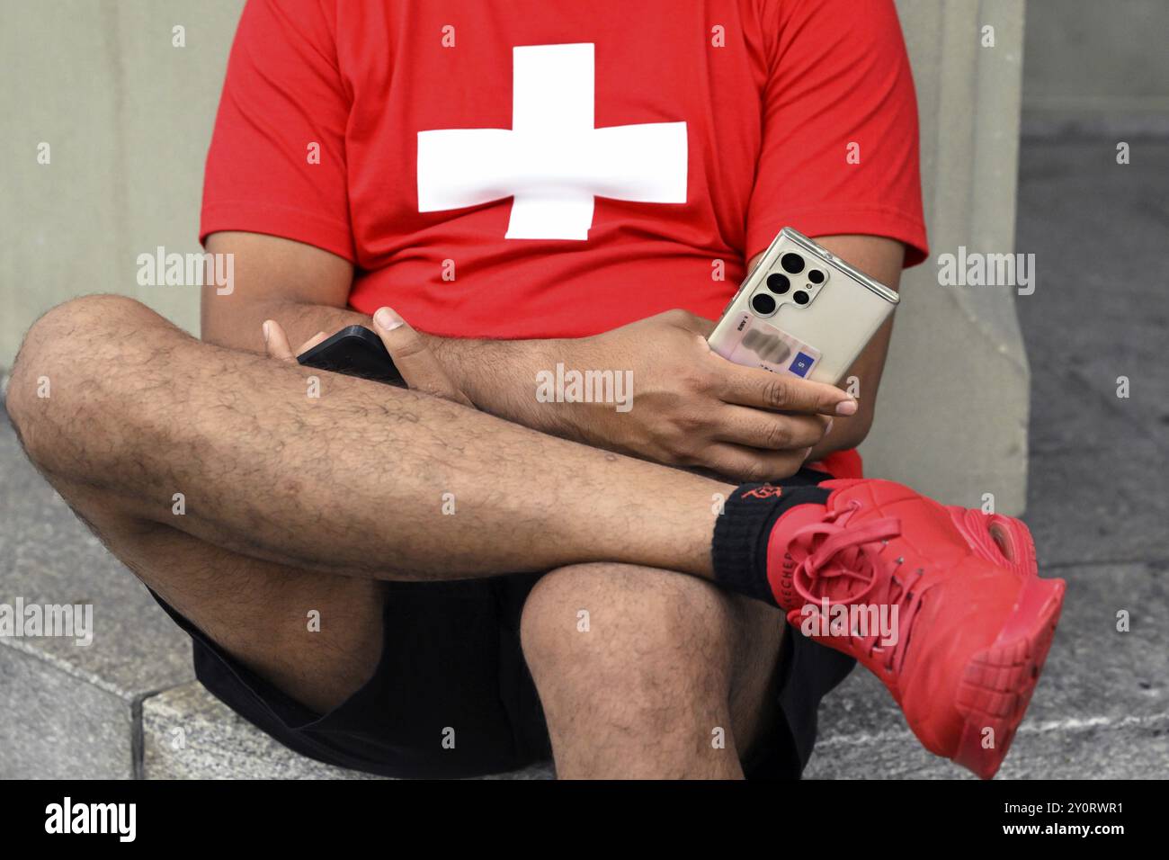 Mann mit Handys und Schweizer Kreuz Stockfoto