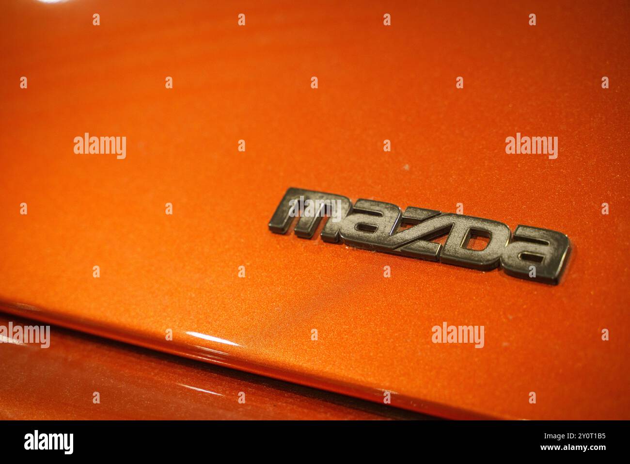 Mazda-Logo auf der orangefarbenen Motorhaube. Hochwertige Fotos Stockfoto