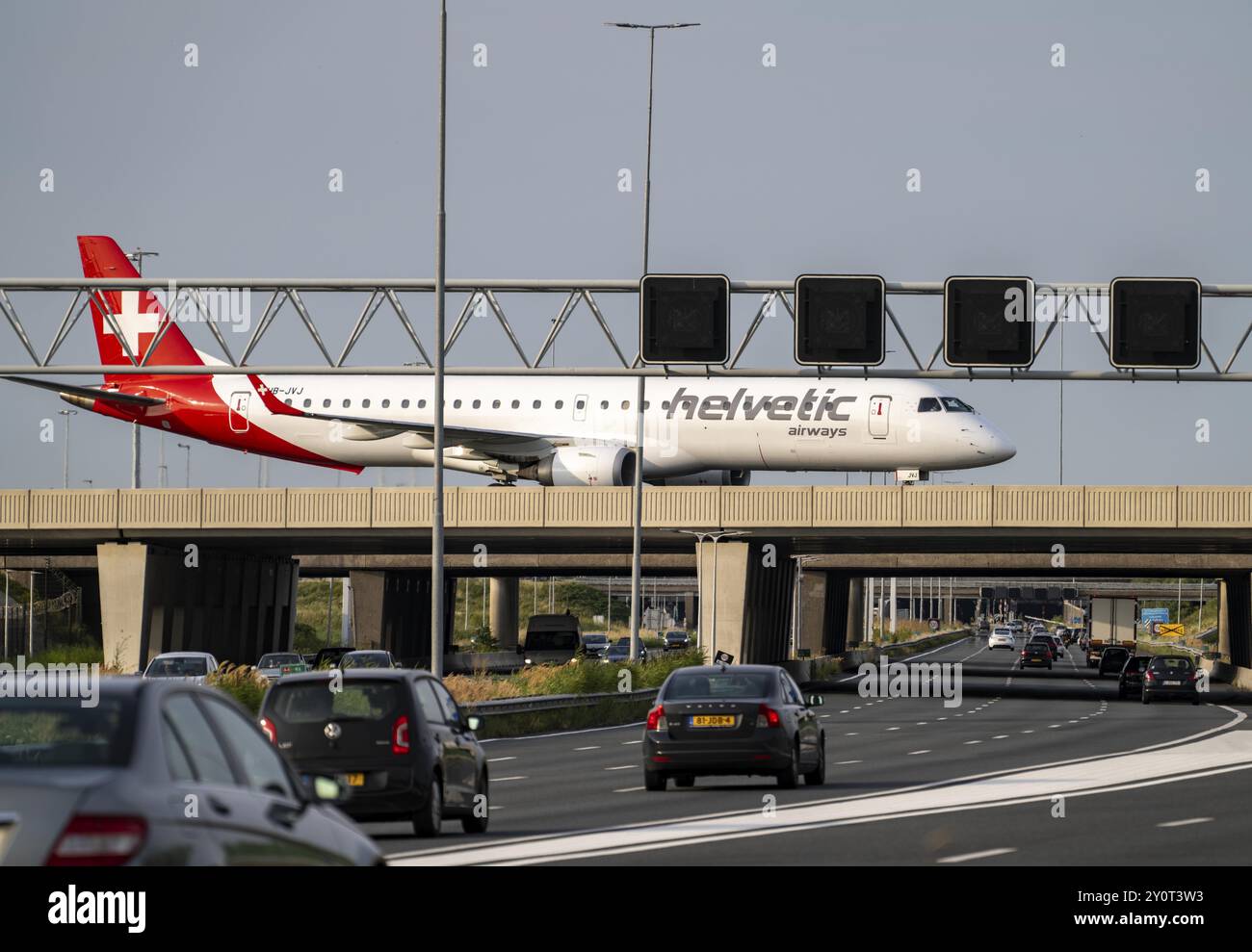 Flughafen Amsterdam Schiphol, Helvetic Airways Embraer ERJ-195, Flugzeug auf dem Rollweg, Brücke über die Autobahn A4, Verbindung von der Polderbaan-Strecke Stockfoto