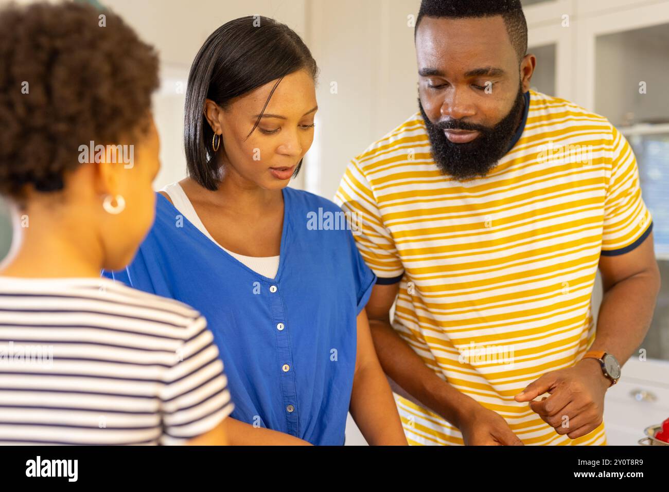 Die Familie bereitet gemeinsam Mahlzeiten in der Küche vor, wobei der Schwerpunkt auf Kochaktivitäten liegt Stockfoto