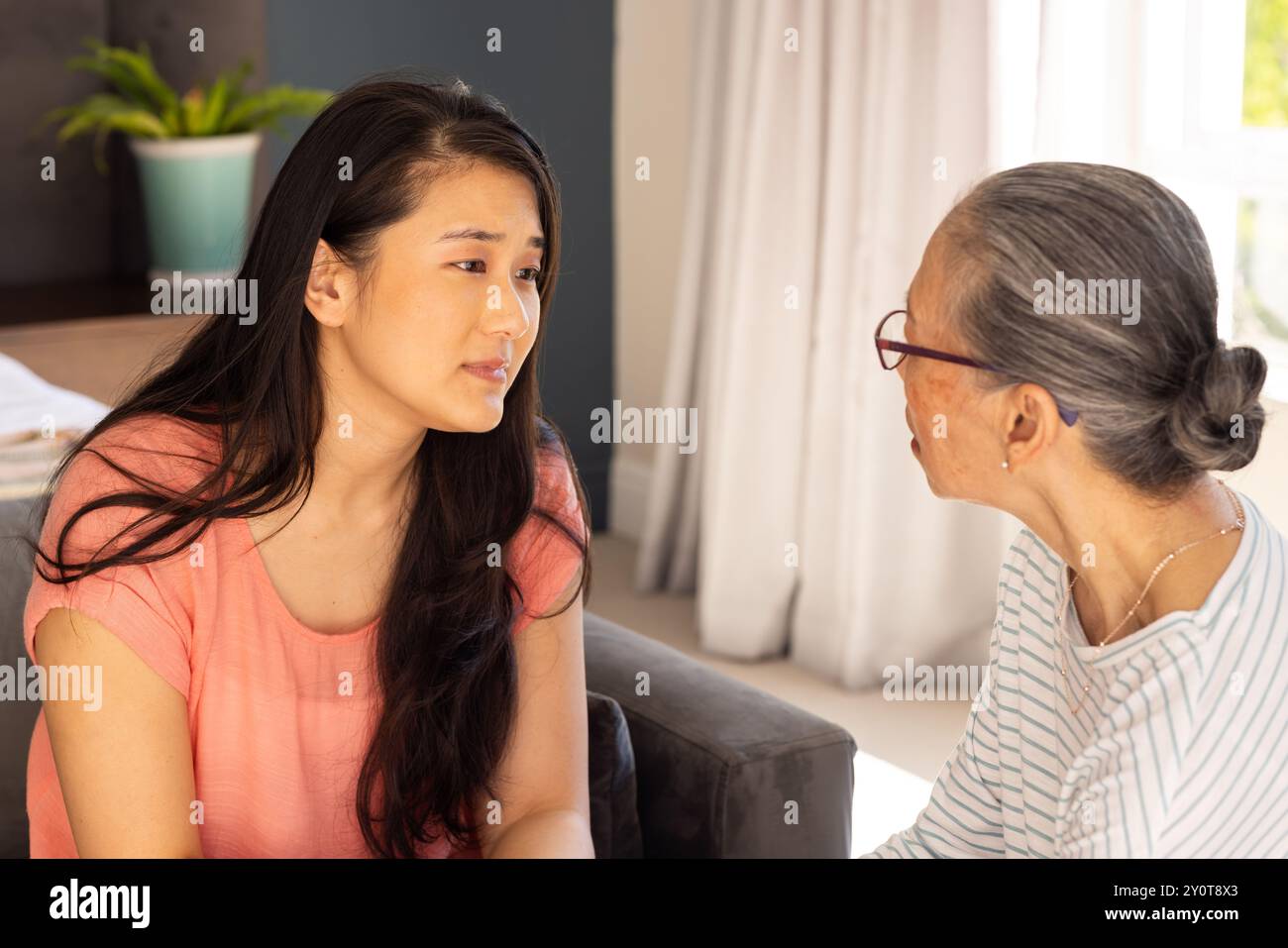 Ernsthaftes Gespräch, asiatische Großmutter und Enkelin sitzen zusammen Stockfoto