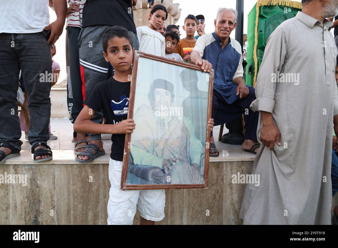 Bani Waled, Libyen. September 2024. Ein Kind trägt während der Veranstaltung ein Porträt des verstorbenen Colonel Muammar Gaddafi. Eine Gruppe von Libyern protestiert und feiert die Septemberrevolution in Bani Walid und fordert die Rückkehr der Herrschaft von Saif al-Islam Gaddafi in Libyen. Quelle: SOPA Images Limited/Alamy Live News Stockfoto