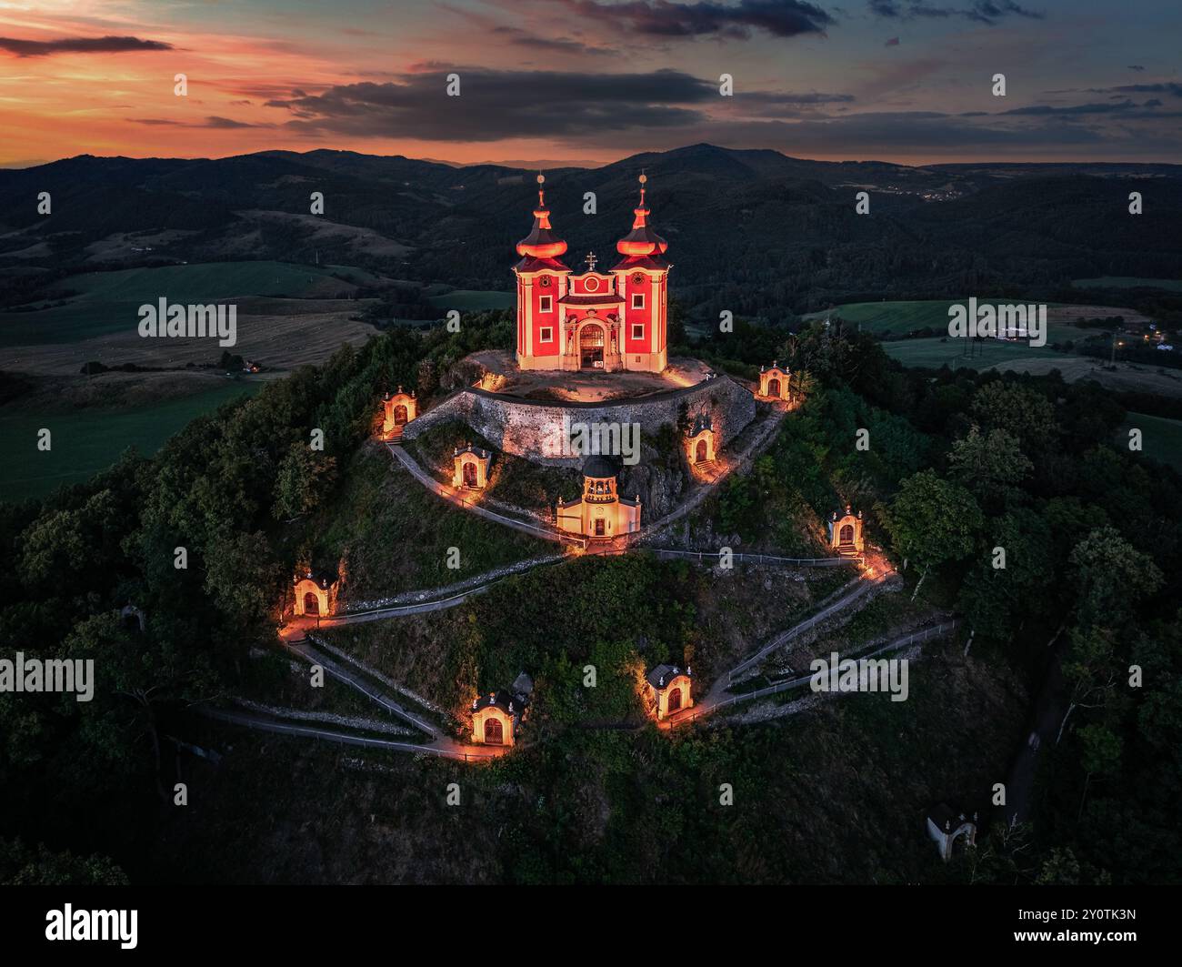 Banska Stiavnica, Slowakei - aus der Vogelperspektive auf den wunderschönen beleuchteten barocken Kalvarienkalvaria in der Slowakei bei Dämmerung an einem Sommernachmittag mit dramatischen bunten Farben Stockfoto