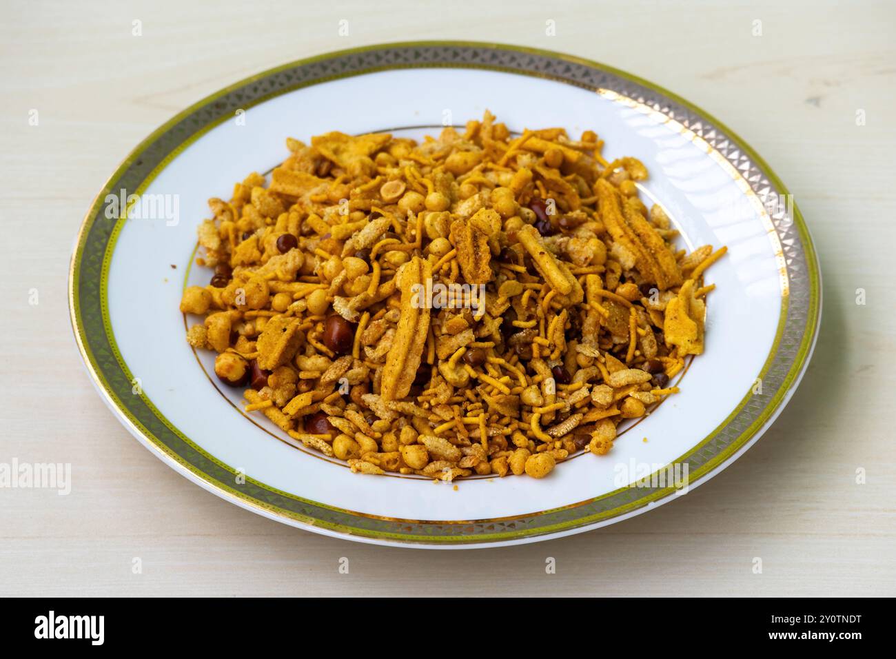 Reichhaltige und scharfe Snacks Bombay Mixed Chanachur auf einem weißen Teller. Nahaufnahme von Bangladeshi Crispy Food Bombay oder Ruchi Classic Chanachur. Stockfoto