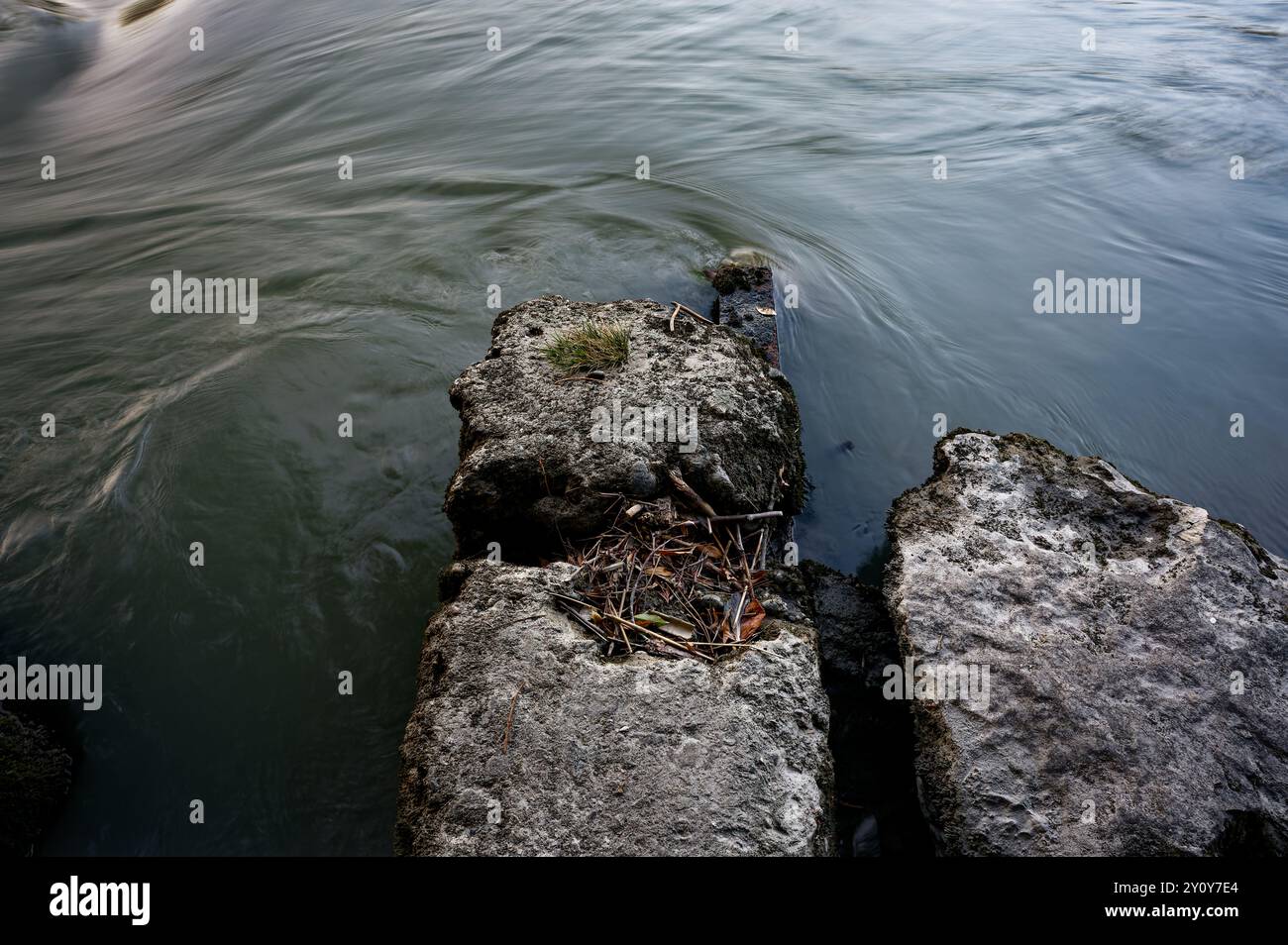 Felsen, die von der Natur verziert sind, inmitten der Gewässer des Flusses arve, die in einer faszinierenden Unschärfe fließen Stockfoto