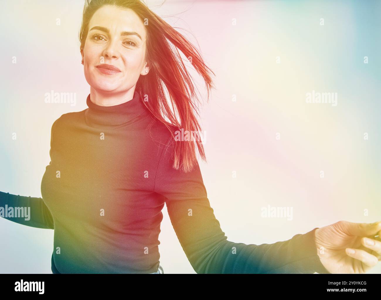 Studio-Porträt einer Frau, die auf die Kamera zuläuft und mit Pastelltönen glücklich aussieht Stockfoto